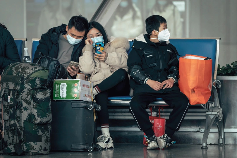 戴口罩的人在机场的长椅上坐着