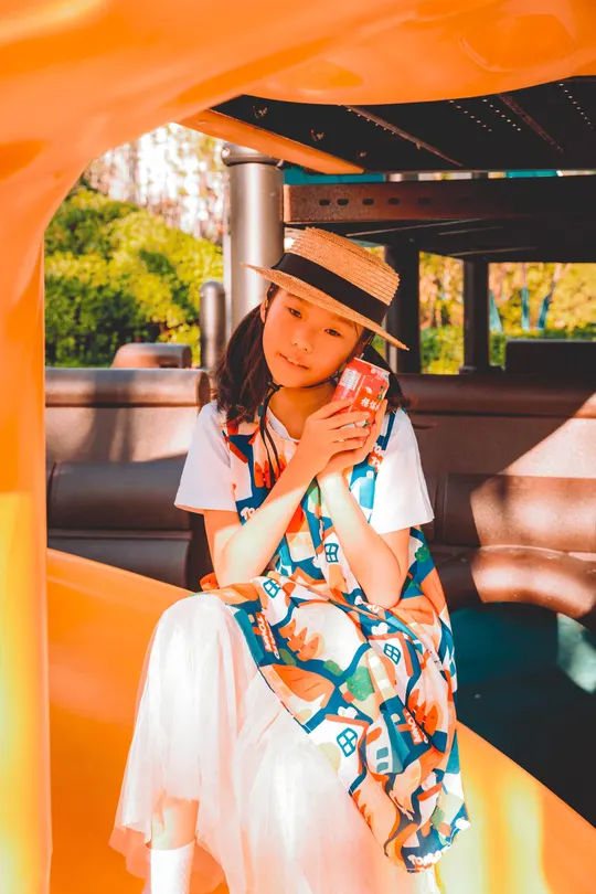 一个穿着连衣裙和帽子坐在船上的年轻女子