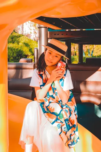 一个穿着连衣裙和帽子坐在船上的年轻女子