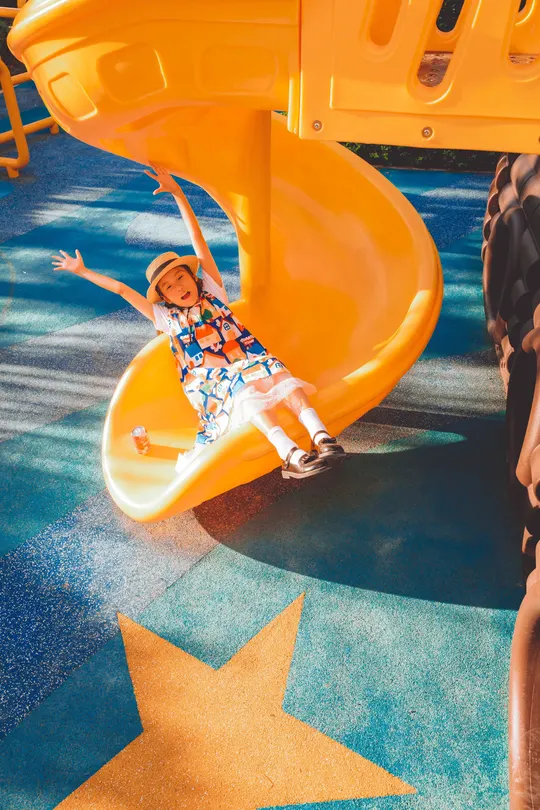 一个年轻男孩和一个小女孩一起在滑梯上滑下来