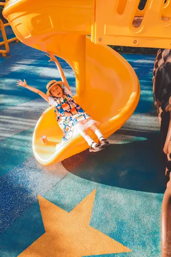 一个年轻男孩和一个小女孩一起在滑梯上滑下来