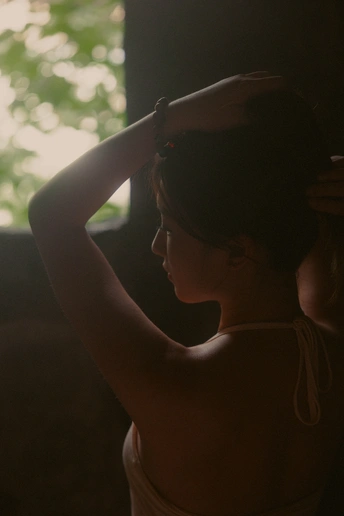 一位年轻女子戴着帽子 正凝视着窗户外。