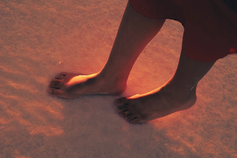 一个人站在沙滩上 光着脚在沙子里