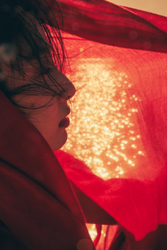 一位年轻女子手持一把带有红色灯光的雨伞