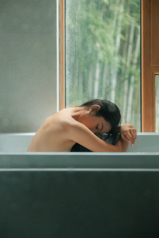 一个坐在浴缸里 靠在窗边 头靠在窗边的女人