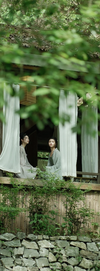 一些女人站在窗前 窗帘是白色的。