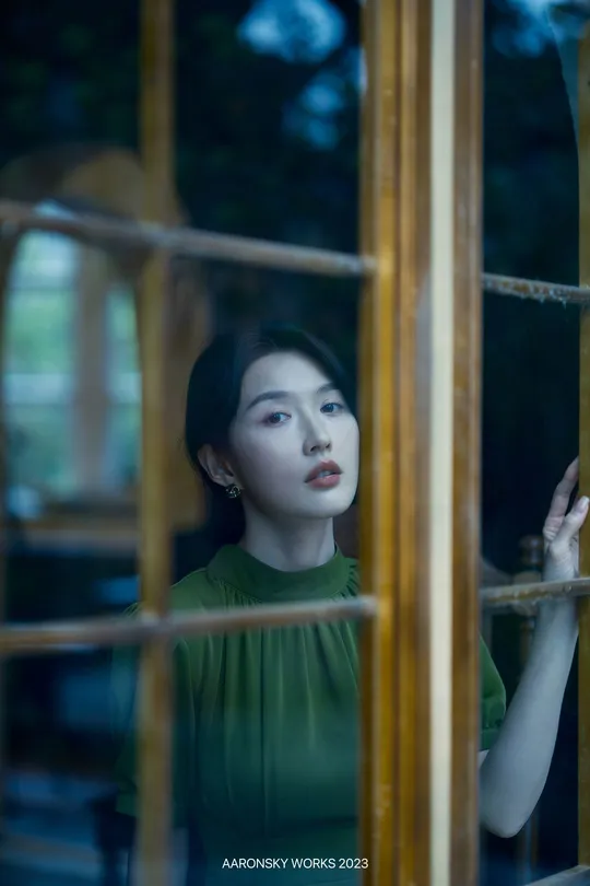 一位年轻女子正在窗口向外看