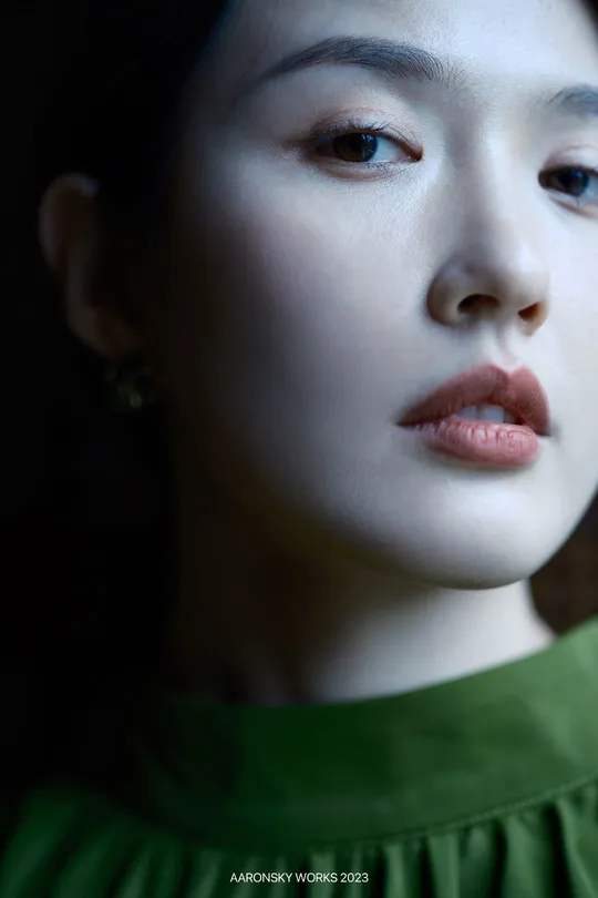 一位穿着绿裙子的年轻女子 眼睛非常突出 由某人绘制。