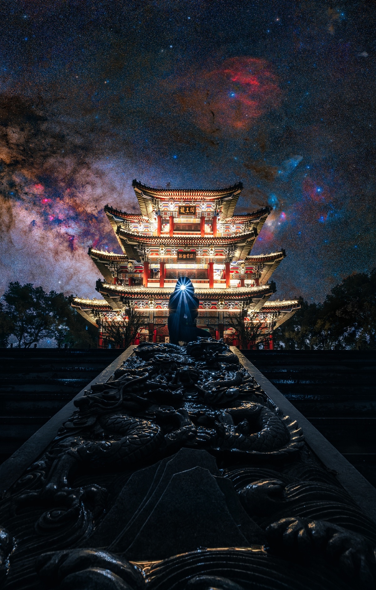一个人站在一个看起来像寺庙的建筑物前 夜晚的天空