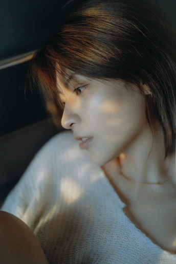 一位年轻女子坐在汽车里 凝视着窗外