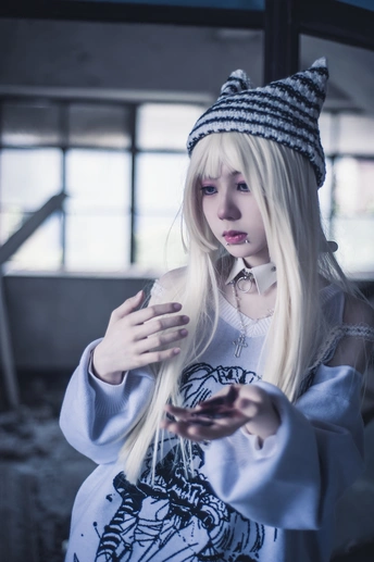 一位戴帽子的年轻女性 留着白头发 正在看手机。