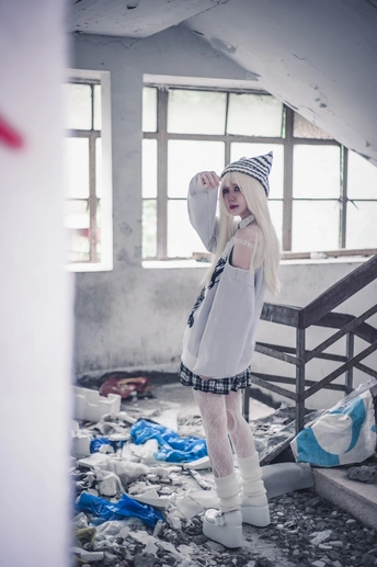 一个女孩站在一座废弃建筑物的白色房间里