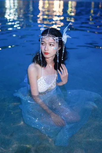 一位穿着蓝色连衣裙在水中的女人