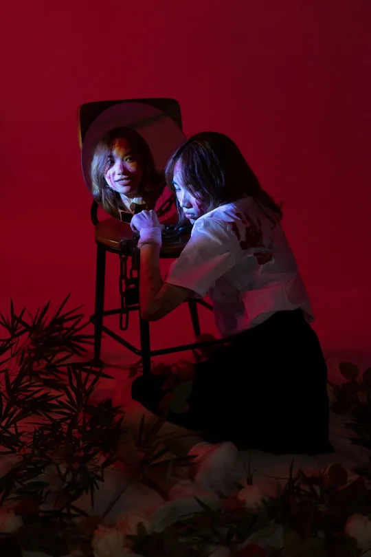 一个妇女和一个小女孩坐在红色房间里的椅子上