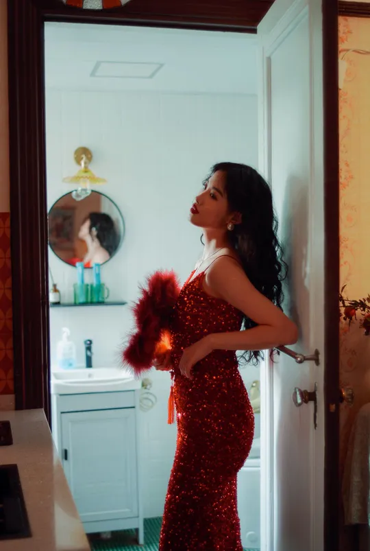 一位穿着红裙子的女人站在厨房里