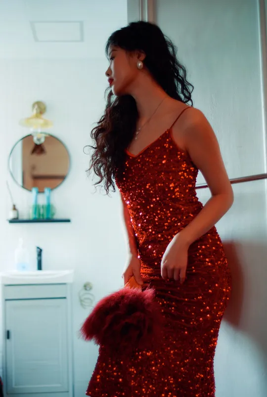 一位穿着红裙子的女人站在浴室里