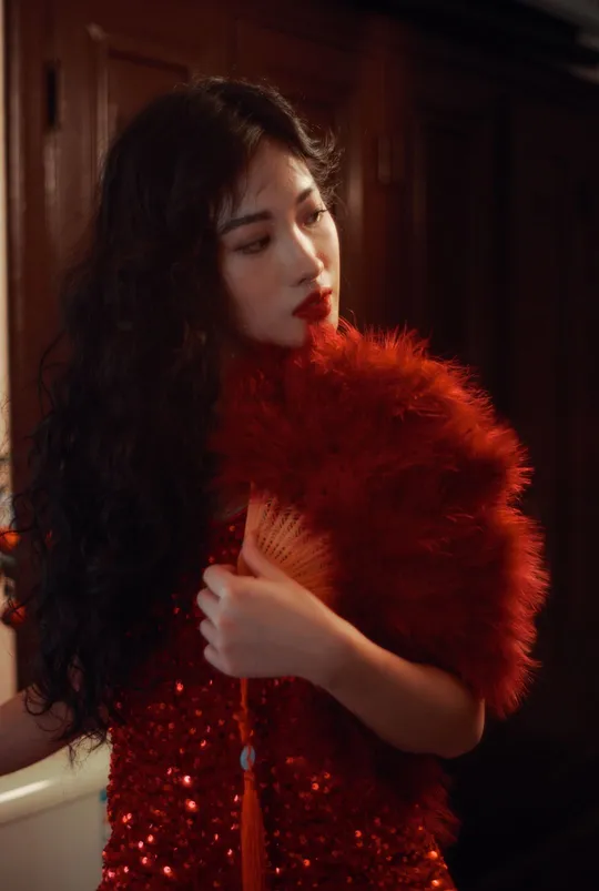 一位穿着红色口红和红色连衣裙 手持红色皮草的女人