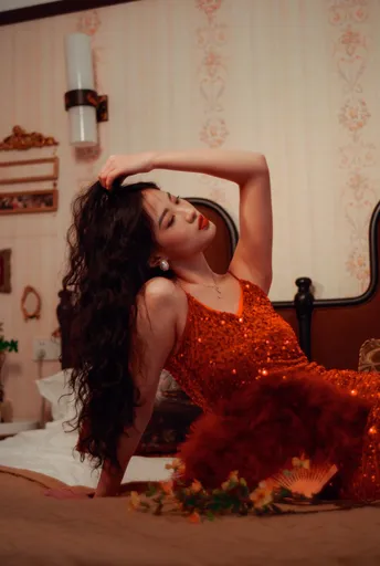 一位穿着红裙子的美丽年轻女子坐在床上