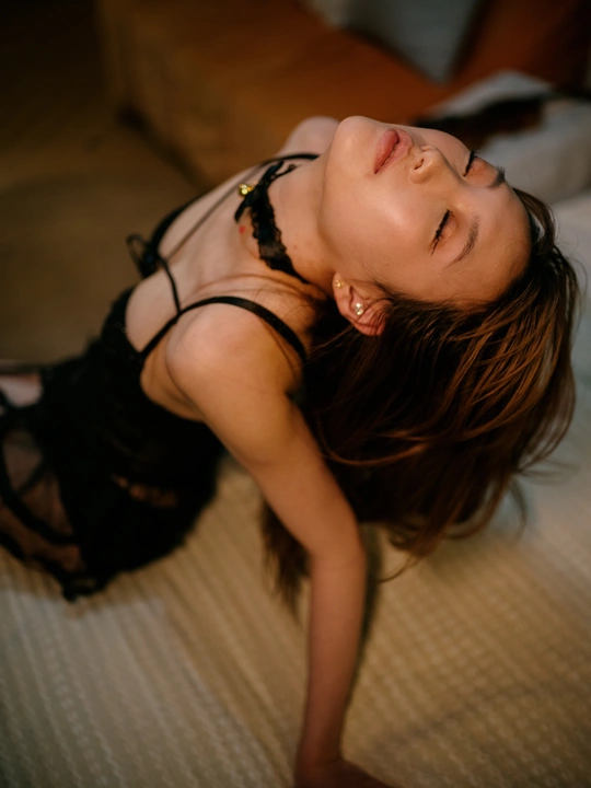 一个穿着黑色连衣裙的金发女子躺在床上