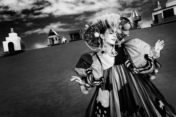 一张黑白照片 一位身着服装的女性站在灯塔前。