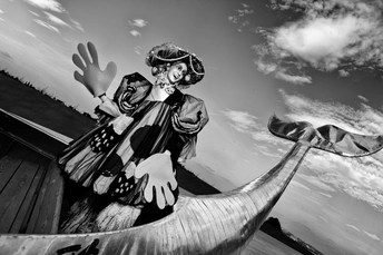 一张黑白照片 一位女士在水上的一艘船上。