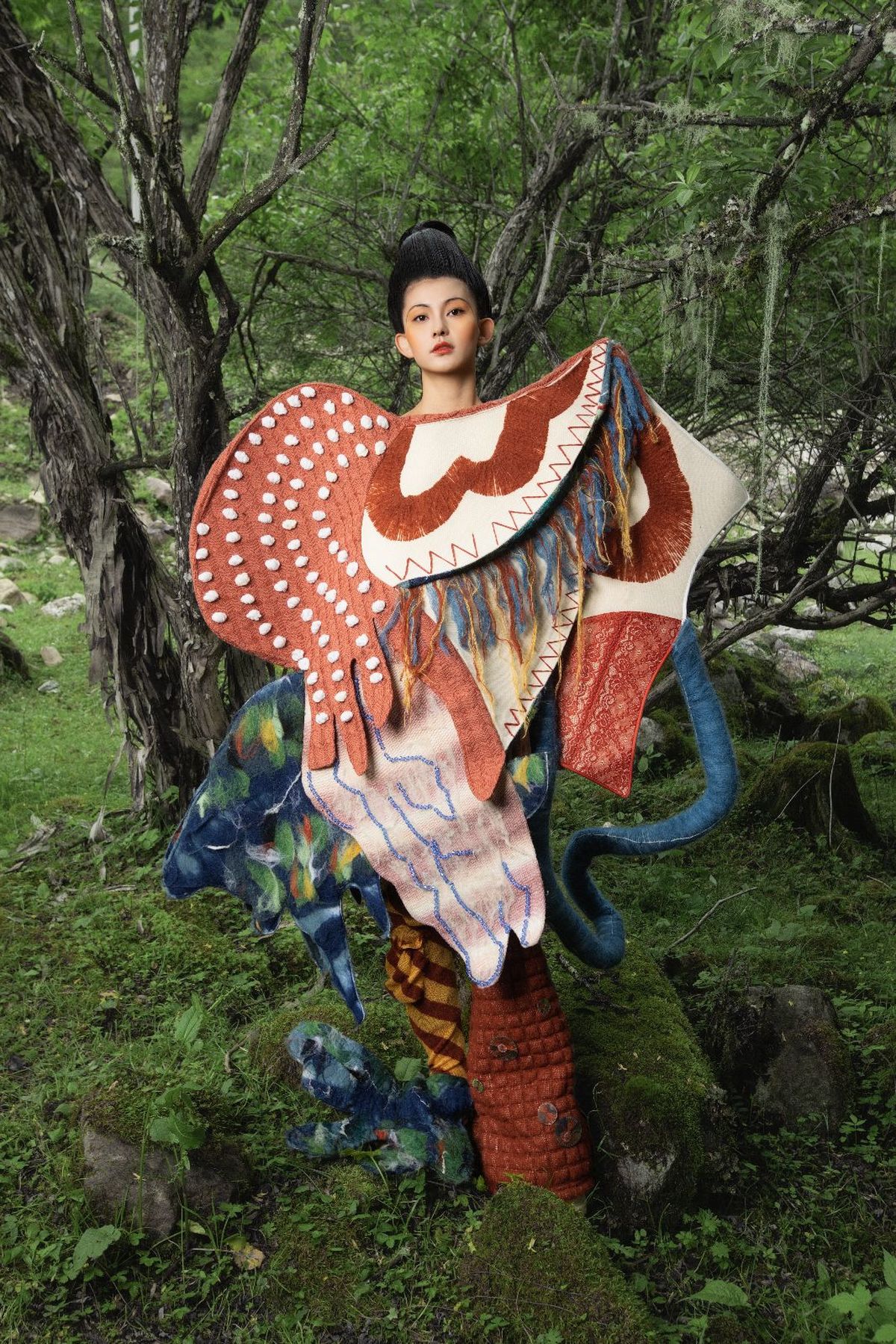 一个穿着雕塑服装的女人站在一棵棵树木组成的森林中。