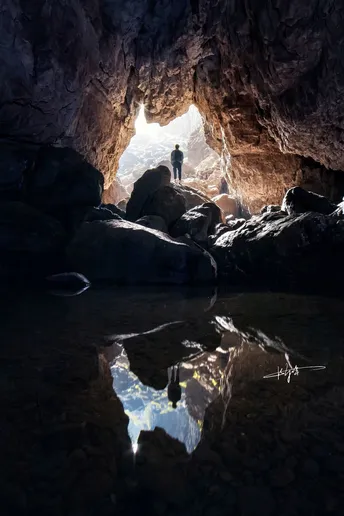 一个人站在一个大型洞穴内的水中
