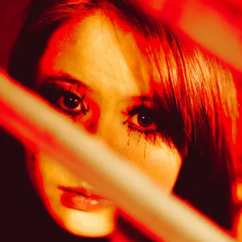 一位女子拿着棒球棒站在镜子前