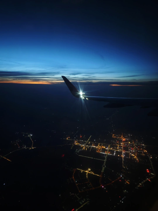 夜晚飞越城市的飞机 云层上有灯光