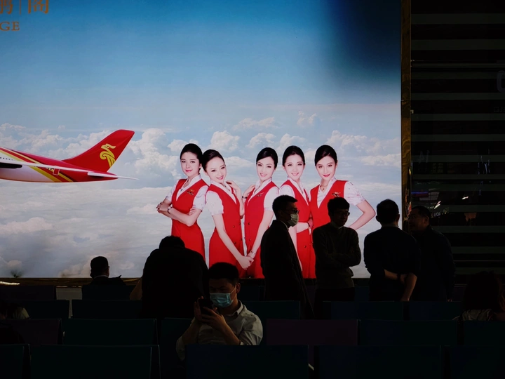 舞台上的女兵们穿着红色制服 背景中有一架飞机。