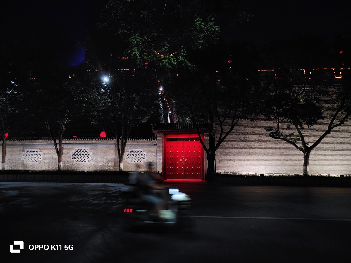 一个摩托车手在夜晚驾驶摩托车 摩托车上有一个发光的红色门 门上有一个发光的红色门
