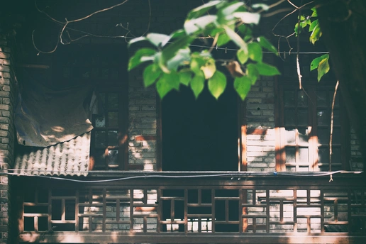 一把木椅子坐在木桌子前面 有一把伞。