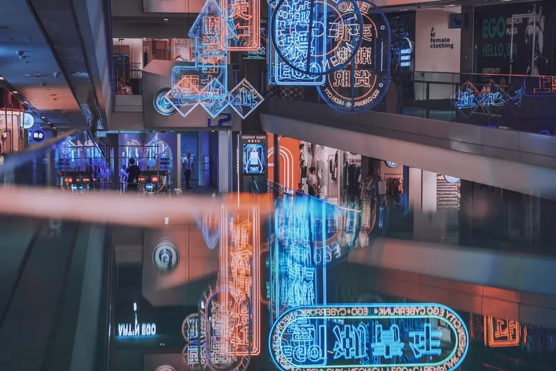 带有大型时钟和蓝色灯光的购物中心内部