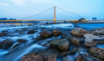 一张长时间曝光的照片 照片背景是夜晚的一条河和一座桥