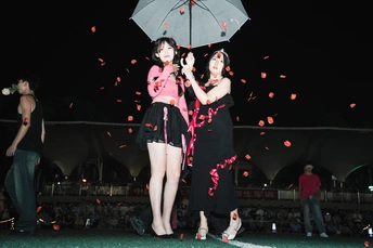 一个穿裙子的女人拿着雨伞站在舞台上