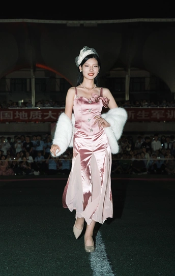 一位穿着粉色连衣裙的模特在活动中参加了时装秀。