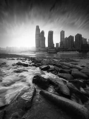 河中有岩石 背景中有城市