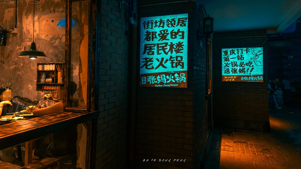 一个夜晚的黑暗房间 一位女士坐在点亮的酒吧前 被一个标志照亮。