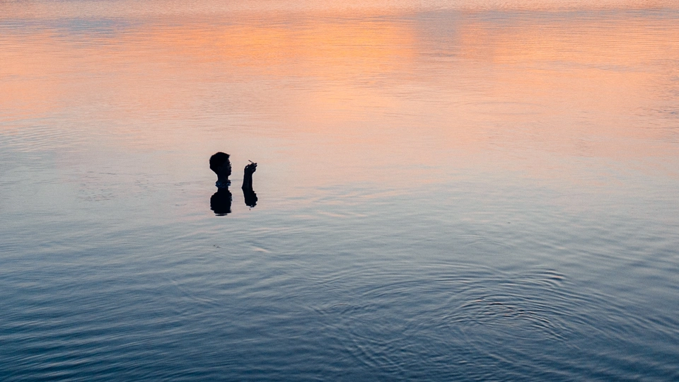 夕阳下在水中漂浮的人