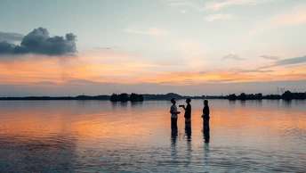 夕阳下在湖中钓鱼的人们