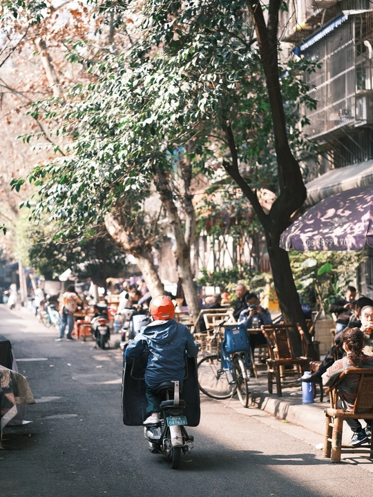一个人骑着滑板车在自行车道上行驶 有自行车的人
