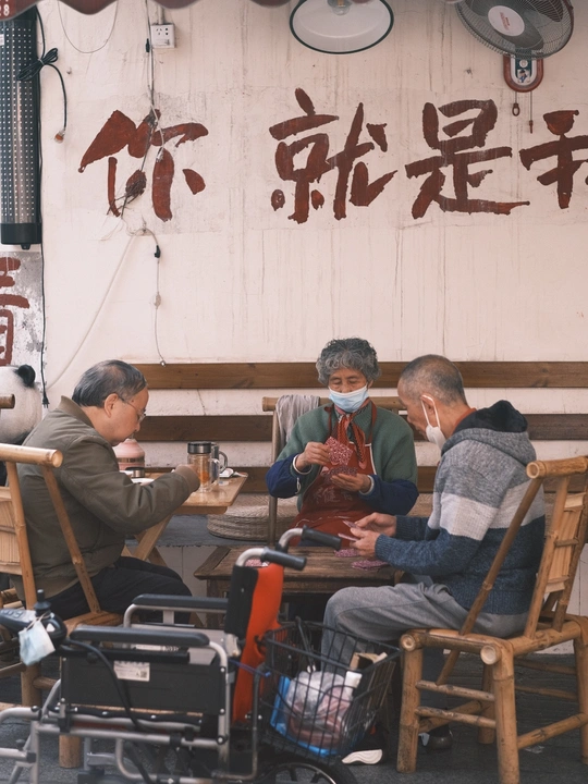 人们在街边餐厅外面的桌子旁坐着