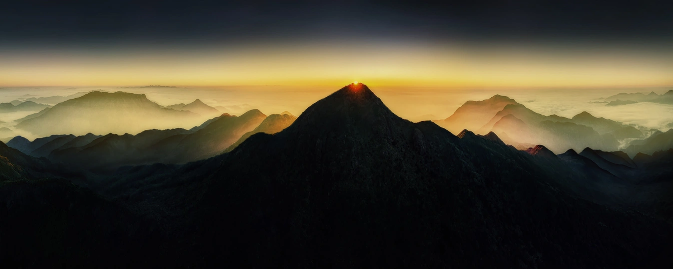 山脉上的日出或日落 太阳升起在云层之上