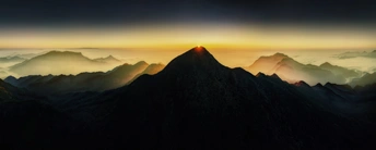 山脉上的日出或日落 太阳升起在云层之上