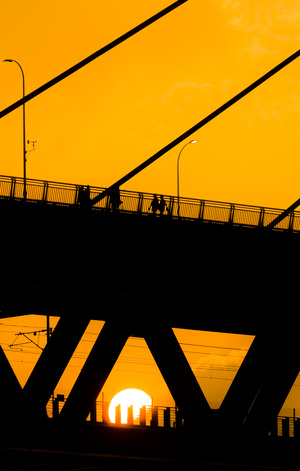 落日时分 人们穿过一座桥的剪影