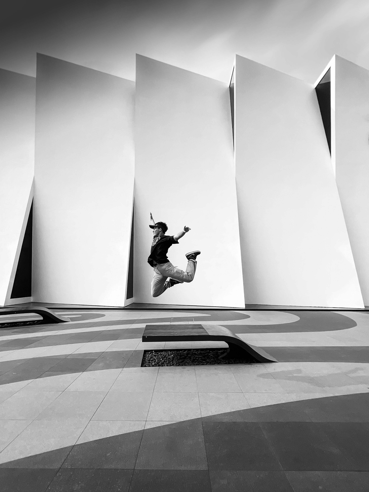 一张黑白照片 一个男人在滑板上跳下墙