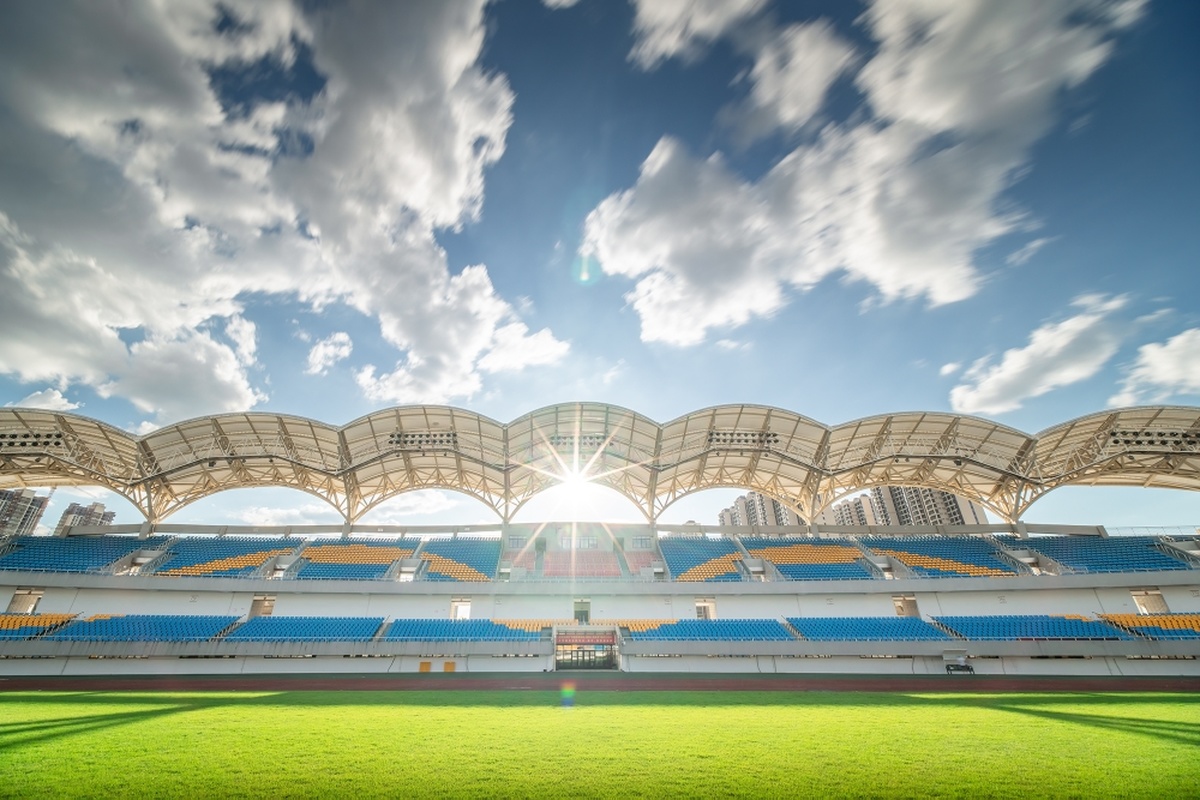 一个大体育场 有绿色的草地和蓝色的天空。