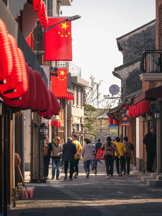 街道上行走的中国城镇中带有红旗的人