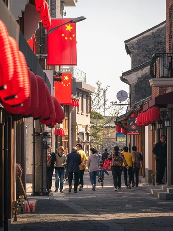 街道上行走的中国城镇中带有红旗的人