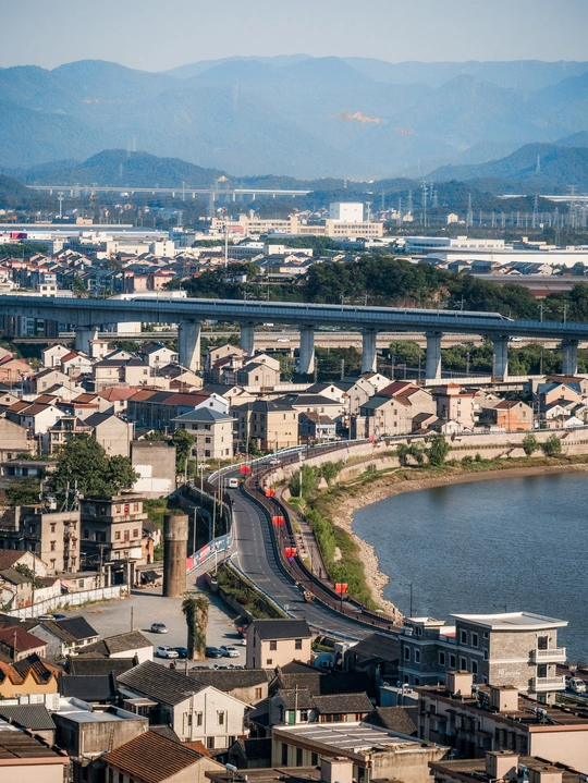 河上有一座大城市 桥上有一列火车 背景是山脉。